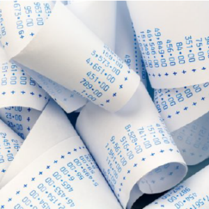 Accounting receipt rolls on a desk, representing financial record-keeping and accounting work.