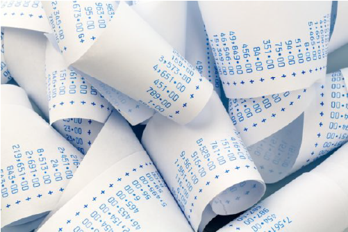 Accounting receipt rolls on a desk, representing financial record-keeping and accounting work.