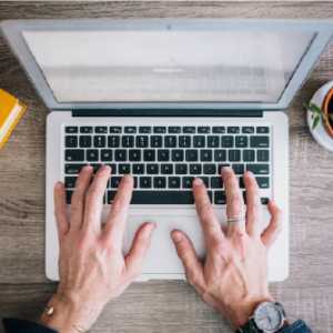 A birdseye view of a business professional using a laptop doing a 1 year online English course