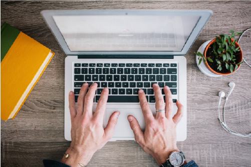 A birdseye view of a business professional using a laptop doing a 1 year online English course