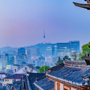 Skyline di Seoul al tramonto con i tradizionali tetti Hanok, che simboleggiano come il patrimonio coreano influenzi la moderna cultura aziendale