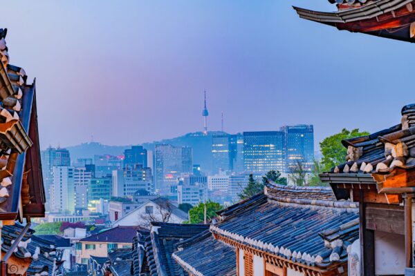 Skyline di Seoul al tramonto con i tradizionali tetti Hanok, che simboleggiano come il patrimonio coreano influenzi la moderna cultura aziendale