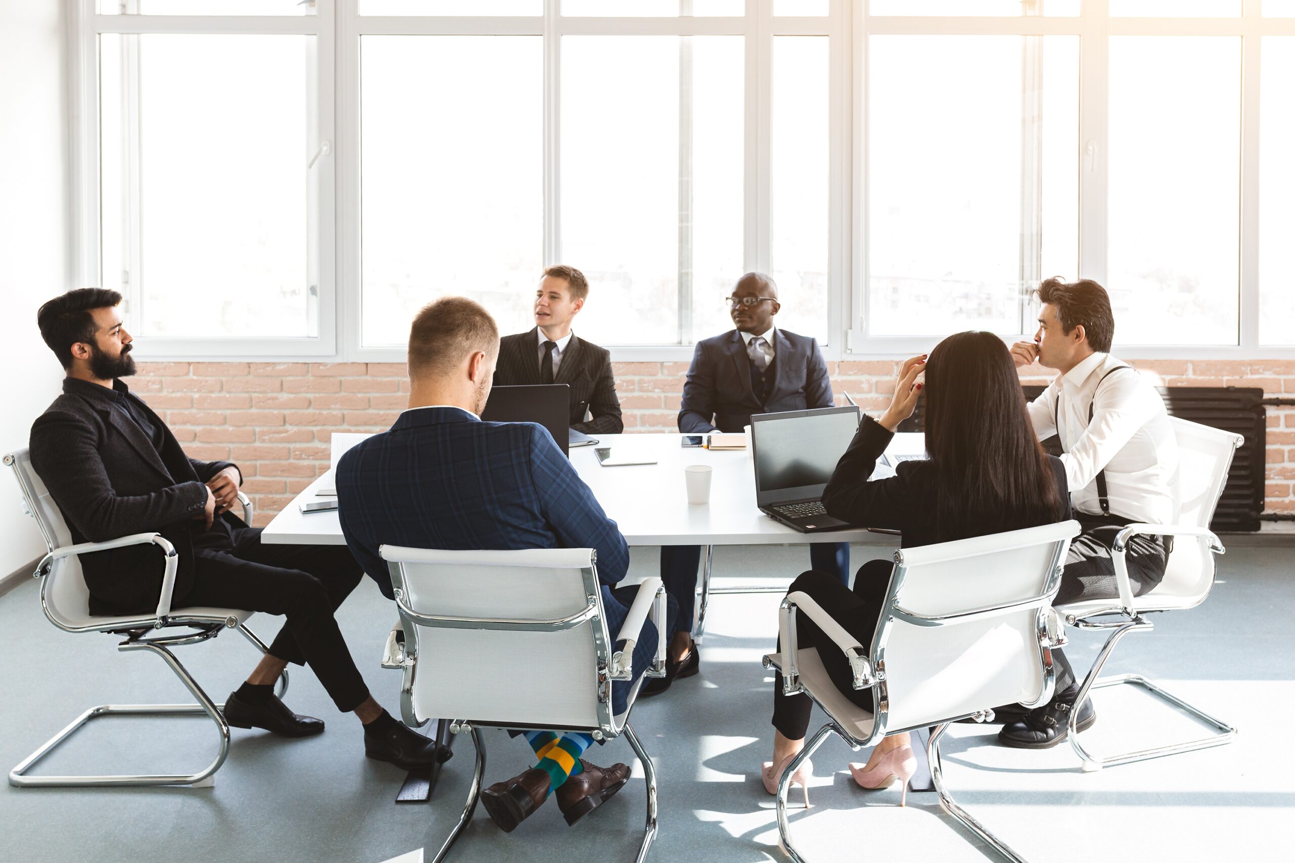 Business professionals in a roundtable discussion, part of a course designed to improve English skills through relevant, topic-based conversations.