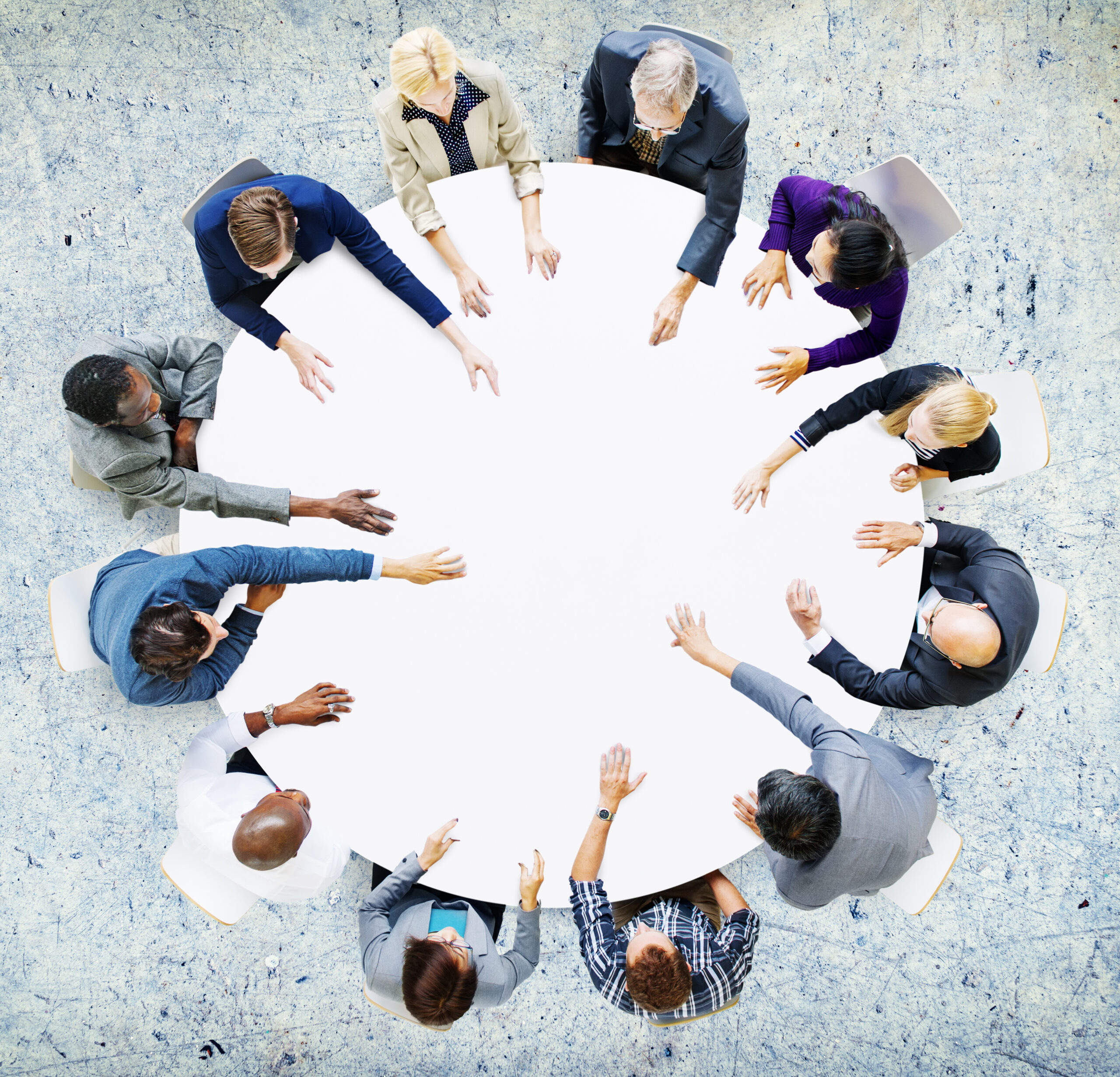 Aerial view of diverse professionals around a round table during a business English speaking Lesson.